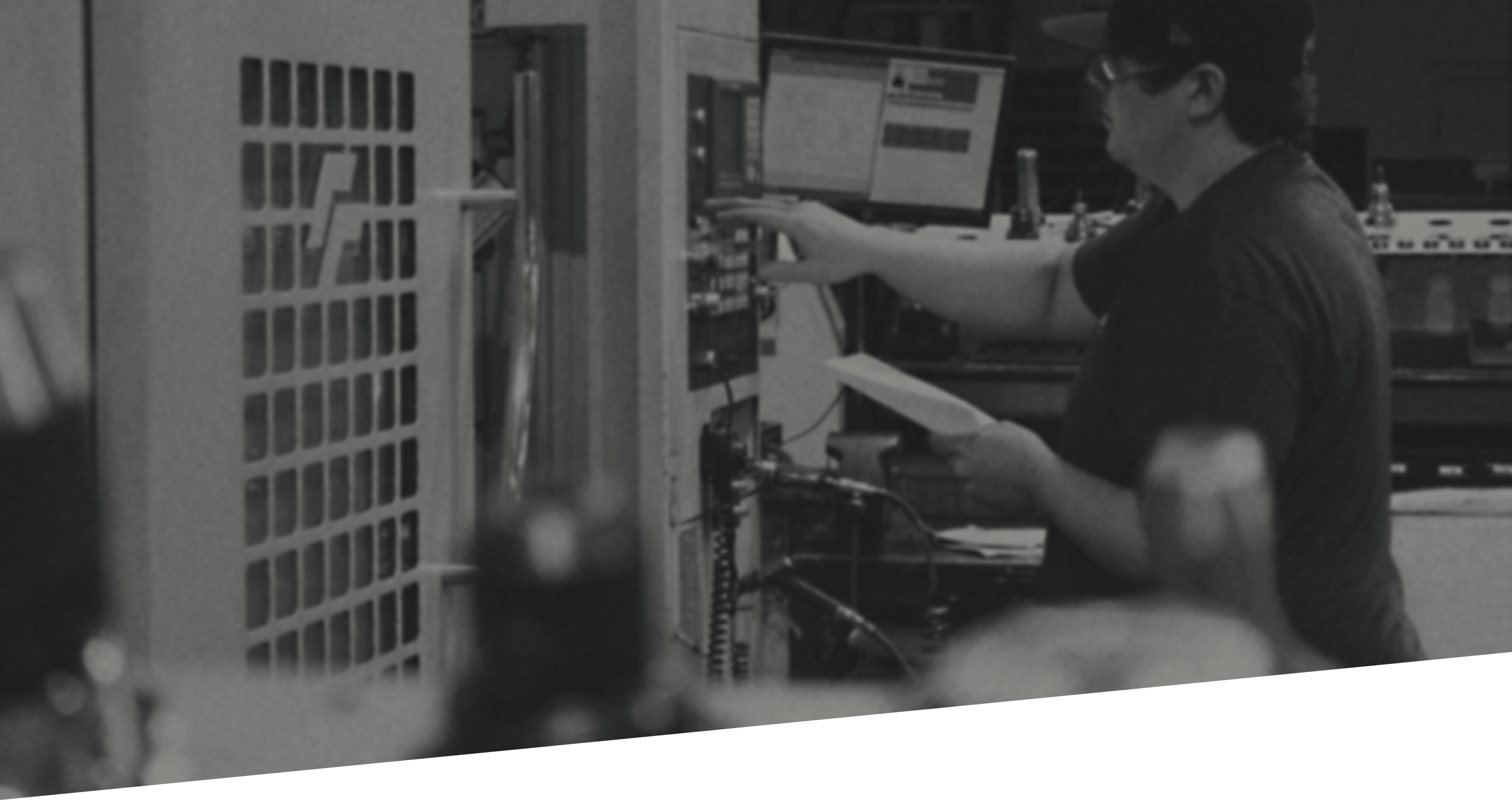 Mechanist inputting data into a data system. The image is black and white and slightly blurred so that the content that overlays it is more visible.